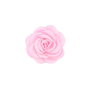 Close-up of handmade pale pink satin camellia flower with layered fabric petals