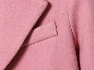 Dettaglio del blazer di lana rosa con colletto e tasca sartoriale dalla trama fine
