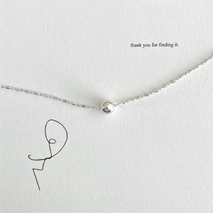 Minimalist S925 sterling silver beaded anklet with round pendant on textured background