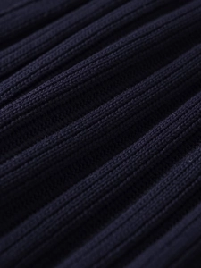 Macro detail of dark blue ribbed knit fabric showing soft texture and vertical patterns