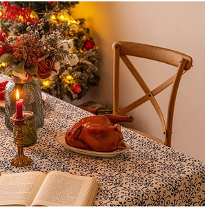 Blue and white patterned Christmas tablecloth on a festive dinner table setting
