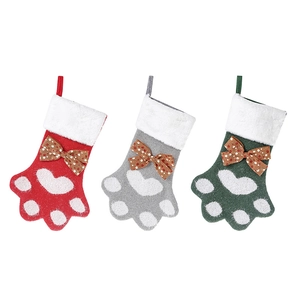 Trois chaussettes de Noël en forme de patte tricotées avec des nœuds à pois de couleur