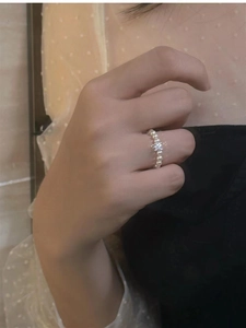 Close-up of elegant pearl and zircon ring on model hand with soft vintage lighting