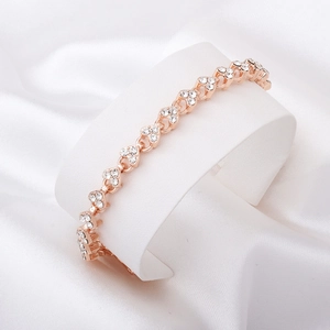 Gros plan d'un bracelet cœur en or rose serti de cristaux sur support en satin