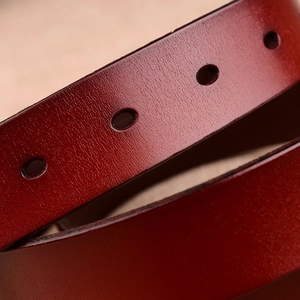 Elegant red genuine leather belt for women featuring detailed texture and buckle holes