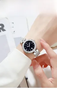 Close-up of a silver watch with a blue starry dial and rhinestones on a female wrist