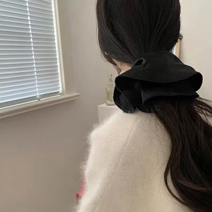 Elegant black satin oversized scrunchie for women shown on a low ponytail hair style