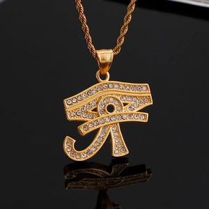 Detailed view of gold Horus Eye pendant with sparkling crystals on black reflective surface