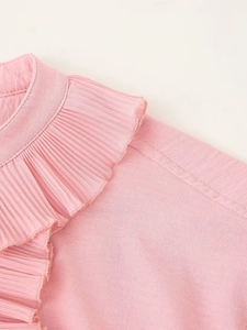 Close-up of pink women's blouse showing pleated neckline and textured fabric details