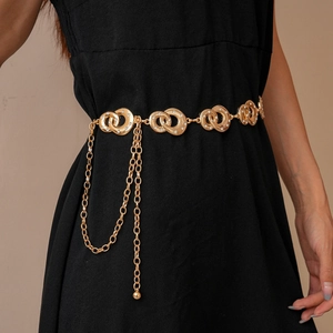 Detailed view of a gold double-ring waist chain with rhinestones on a black dress