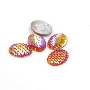 Detailed macro view of orange fish scale teardrop resin gems with a rainbow AB finish