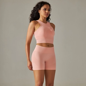 Detail of pink seamless knit yoga set featuring ribbed high-waist shorts and sports bra