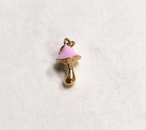 Detail of pink enamel mushroom charm with polished gold metal stem for DIY jewelry making