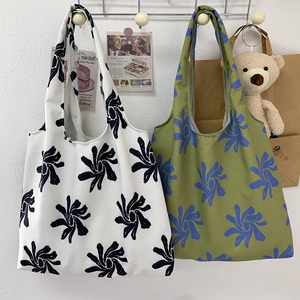 Detail of artistic floral canvas tote bags in black-white and green-blue patterns