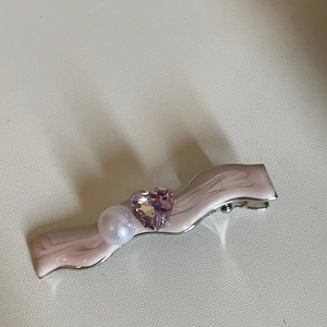 Barrette à cheveux rose ondulée avec perle blanche et zircon cœur violet sur fond beige