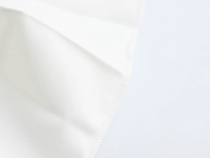 Makrodetail der eleganten gefalteten weißen Stofftextur mit Präzisionsnähten und Saum