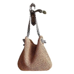Brown woven straw shoulder bag with black and white striped straps hanging on hook