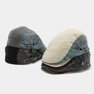 Detail of vintage patchwork cotton newsboy caps with metallic side buckles and textures
