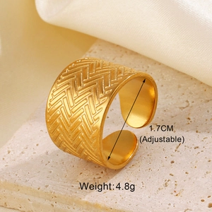 Macro detail of golden geometric wide band ring with chevron engraving on stone surface