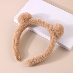 Detail of plush camel headband with fuzzy pom-pom ears for skincare and makeup routines