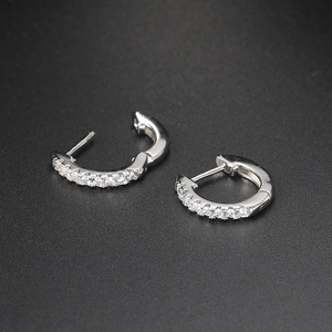Detailed macro view of silver steel hoop earrings with sparkling cubic zirconia crystals