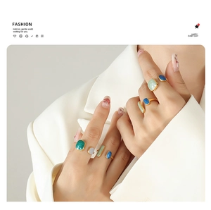 Detail showing adjustable gold-plated stainless steel rings with colorful enamel inlays