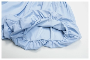 Detail of light blue yoga shorts showing elastic pleated hem and quick-dry fabric texture