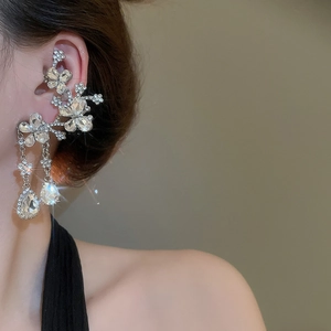 Close-up of sparkling crystal flower tassel earrings worn on a model for a luxury look