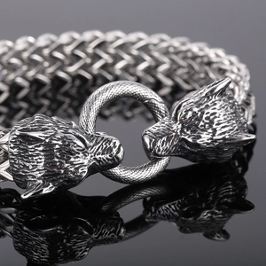 Detail of Viking style wolf head bracelet in antique silver finish with woven chain