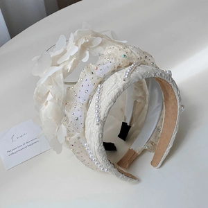 Close-up of elegant white pearl hairbands with lace and rhinestone details