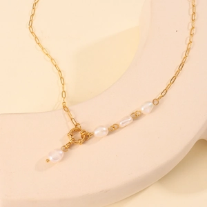 Macro detail of natural irregular pearls on a minimalist 18K gold stainless steel chain
