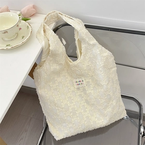 Detail of 3D jacquard fabric texture and colorful logo label on cream white tote bag