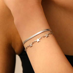 Gros plan du bracelet double rangée en acier inoxydable argenté avec pendentifs étoile