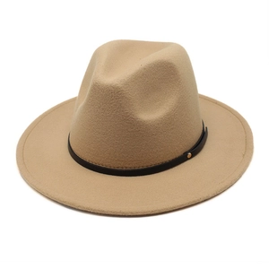 Detail of camel wool fedora hat featuring a black leather band and gold metal rivets