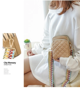 Detail of khaki quilted crossbody bag featuring a colorful ethnic woven shoulder strap