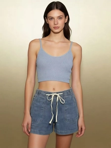 Detail of light blue denim shorts with drawstring elastic waist and washed fabric texture