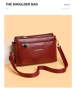 Detail view of burgundy PU leather shoulder bag with three layered silver zippers and texture