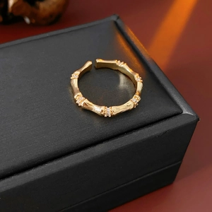 Vue détaillée d'une bague bambou dorée avec zircons sertis sur un coffret noir