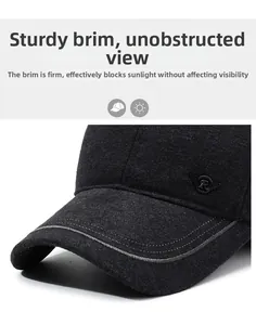 Detail of a charcoal baseball cap with a firm brim and metal wing logo emblem