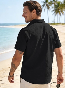 Rear view of men's black seersucker shirt featuring textured cotton linen fabric on beach
