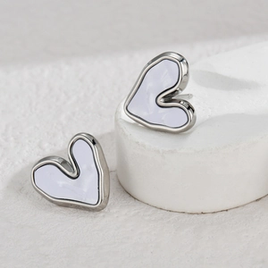 Irregular silver-framed lavender enamel heart stud earrings on white stone display