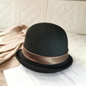 Detail of a black wool felt bowler hat featuring a brown satin decorative ribbon band