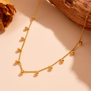 French style gold stainless steel bead chain necklace on a rustic natural background