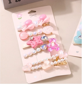 Détail d'un lot de 5 barrettes roses pour enfants avec ours, cœur et perles en résine