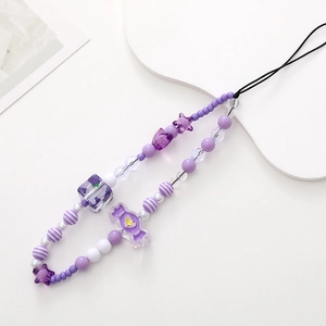 Detail of purple beaded phone strap with candy and star shapes on white tray