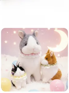 Detailed view of three fluffy plush bunnies with lace collars in grey, brown and black colors
