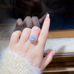 Detail view of 4-carat cushion cut moissanite ring with halo diamonds on model finger