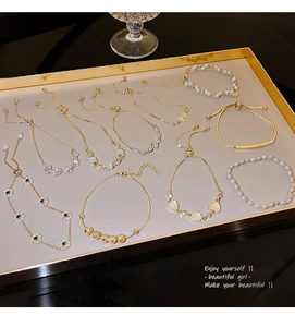 Detail view of gold luxury pearl bracelets with zircon flower charms and opal heart pendant
