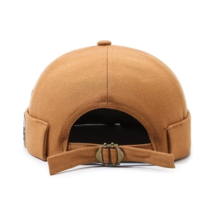 Brown docker hat in cotton twill featuring an adjustable metal buckle and side patch