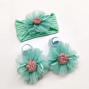 Detail of mint green baby headband and matching socks set with large mesh flowers